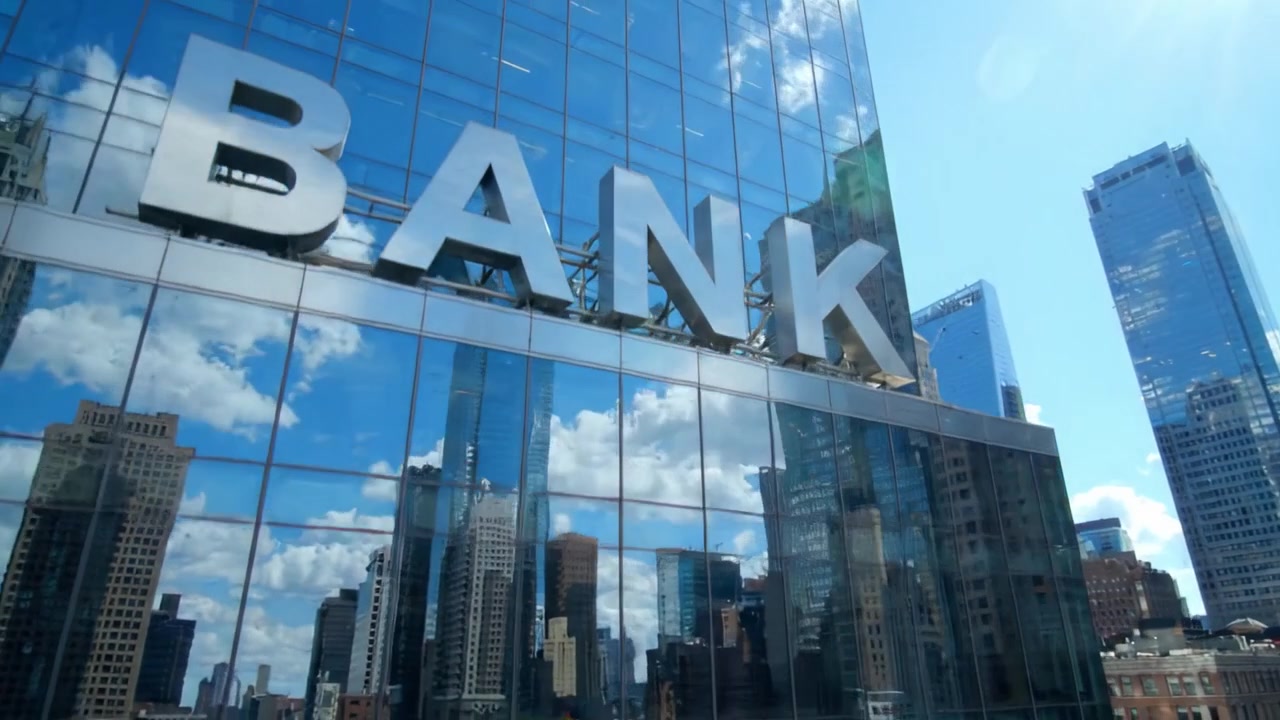 Um Edifício Bancário Urbano Moderno Refletido em Fachada de Vidro Cercado por Arranha-céus e Vida Urbana Vibrante Sob um Céu Azul Claro