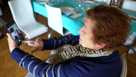 Elderly-woman-gets-fascinated-using-smartphone-to-take-a-selfie-at-home