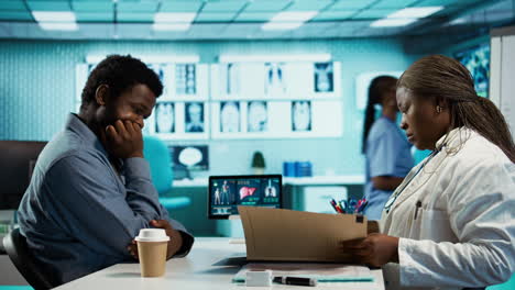 black male patient bringing x ray test results to medic for scan interpretation