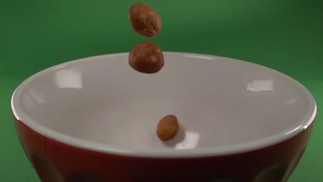 front view of japanese peanuts falling on a plate