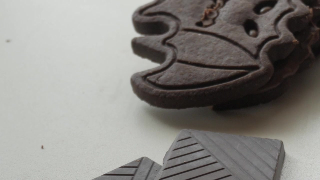 Primo piano di biscotti a forma di pipistrello spettrali, dolcetti di cioccolato fondente per Halloween, slow motion, ripresa con carrello verticale con spazio per il testo