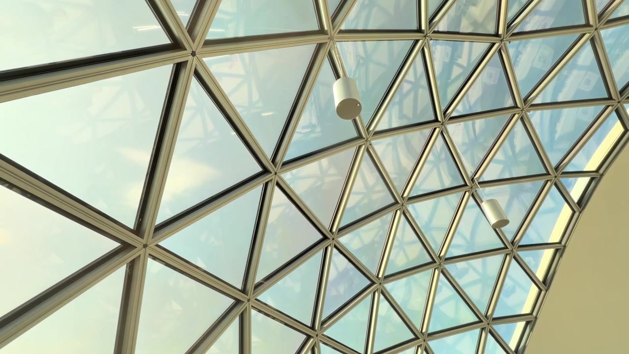 Interior view of geometric glass dome ceiling with modern lighting fixtures