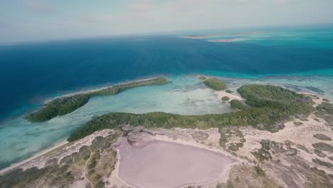 Aerial-view-pan-left-Agustin-island-with-pink-lagoon,-los-Roques-Archipelago-caribbean-sea