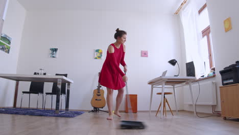 Girl-sweeping-floor-and-dancing,-work-is-fun,-interior-low-angle-slider-view