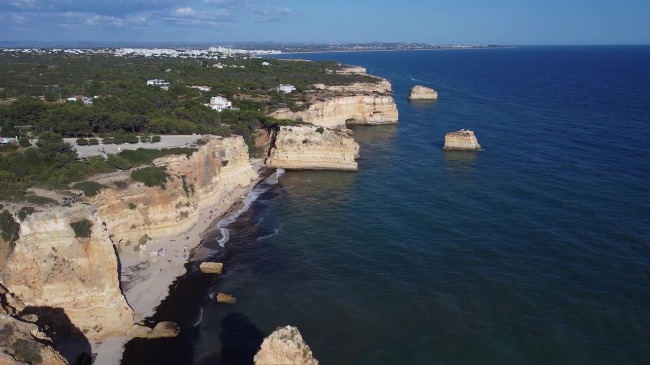 Una prospettiva aerea rivela le bellissime scogliere dorate e le acque blu della costa dell'Algarve in Portogallo. Goditi questa vista panoramica diurna dell'Oceano Atlantico che incontra la costa frastagliata