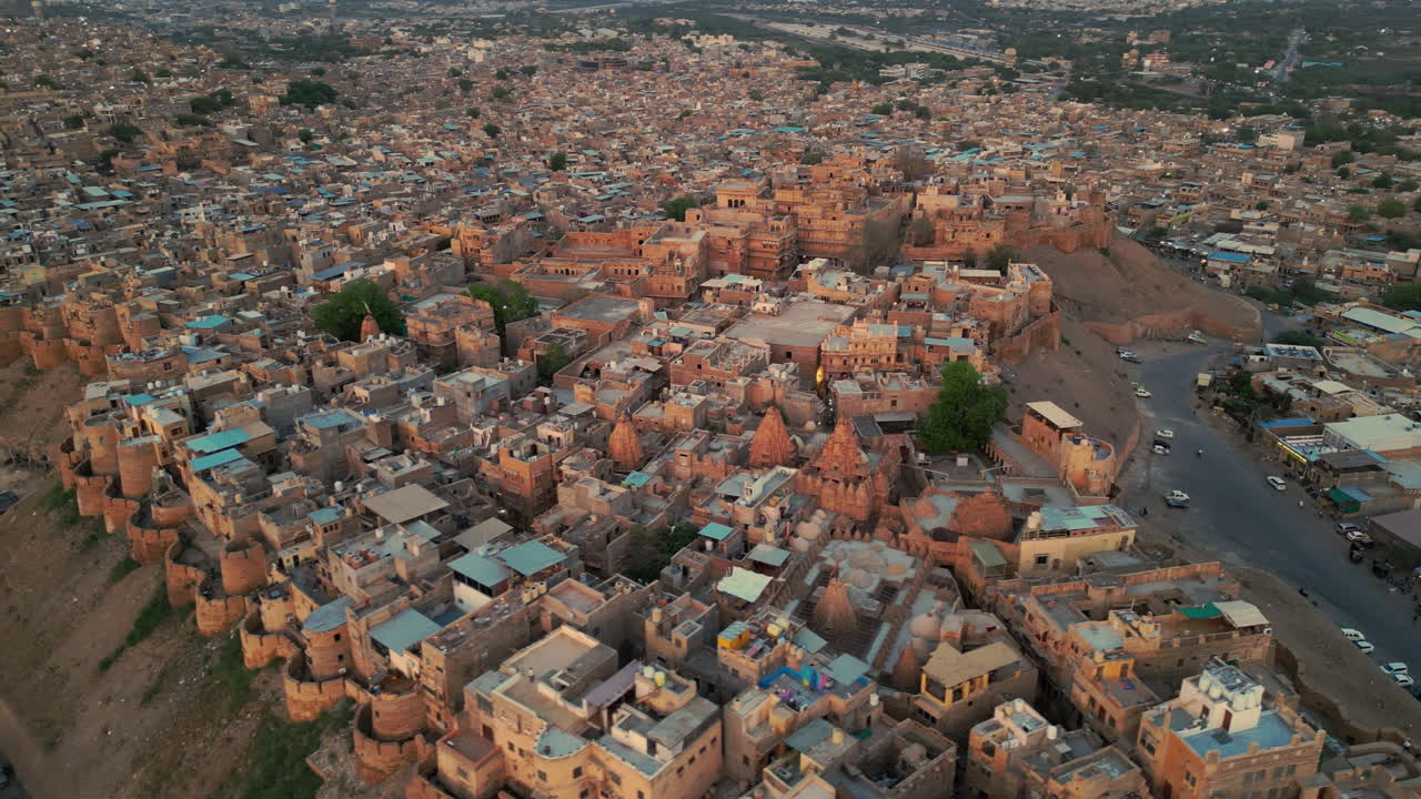 una toma de un dron en órbita del fuerte de jaisalmer, rajasthan, india a la luz del día. el fuerte de piedra arenisca dorada se erige alto rodeado de casas densamente abarrotadas.