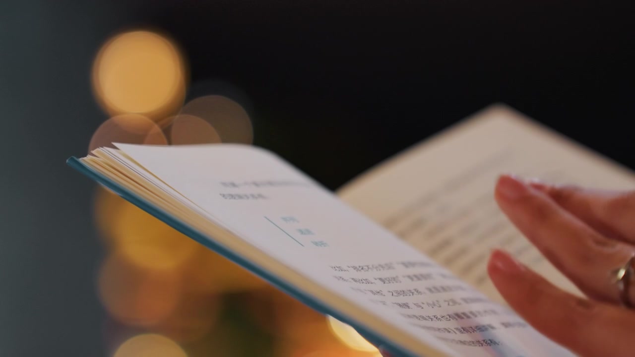 Nærbilde om natten av bokblader som snur, forsiktig hånd som blar sider mot varme bokeh-lys, grunn dybdeskarphet og teksturert papir, intim kveldslesestemning, mykt omgivende lys og ensom ettertenksomhet.