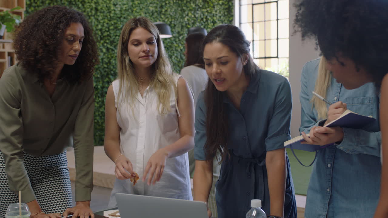donne d'affari multietniche che si incontrano, che fanno brainstorming insieme, che sono leader di squadra, che condividono idee creative, che pianificano strategie di sviluppo utilizzando la tecnologia del portatile nel moderno luogo di lavoro in ufficio