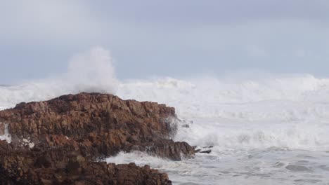 salvajemente tumultuosa ruptura de la costa de aguas bravas crea spray y espuma de mar