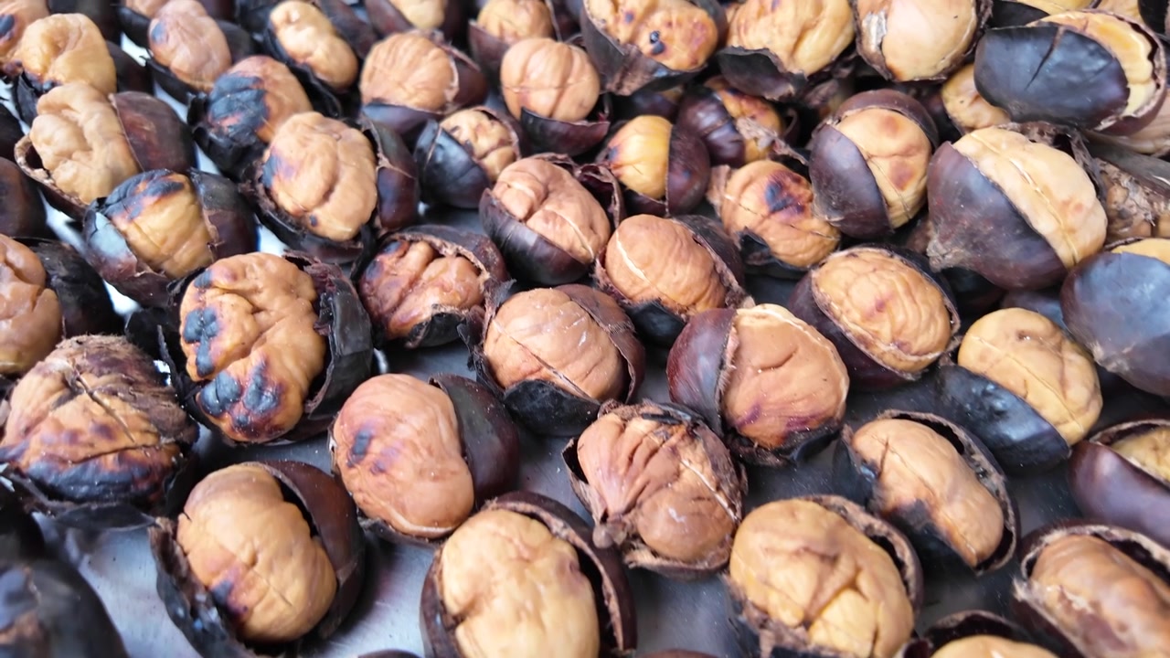 Castagne appena arrostite su un vassoio di metallo