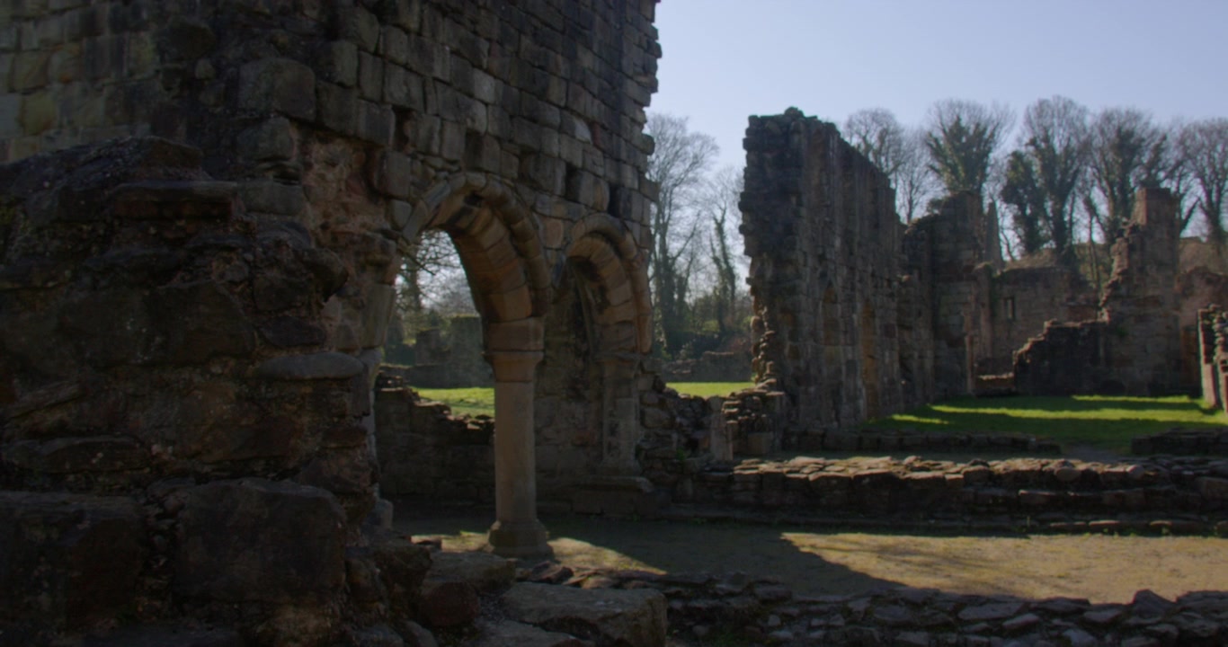 Inquadratura con zoom ampio sugli archi in pietra dell'Abbazia di Basingwerk
