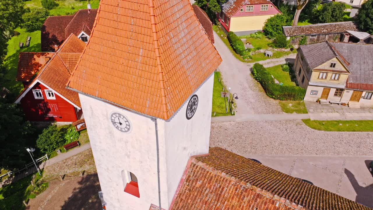 Drone glides down near Talsi Lutheran Church tower Latvia on bright sunny summer