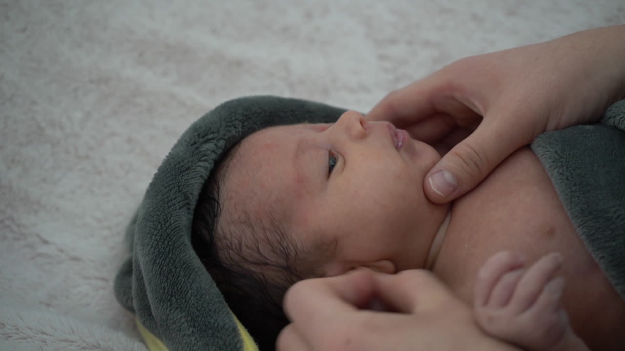 Cleaning ear of baby after the first bath in hospital