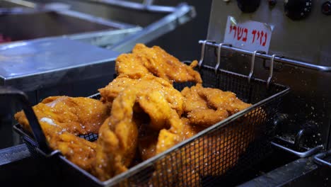 fresh fried meat with sesame seeds in commercial kitchen, food preparation