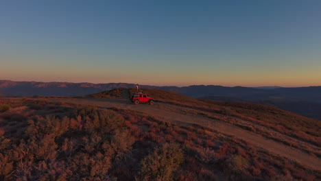 Young-man-on-top-of-Roof-jeep-dancing-at-breathtaking-mountain-desert-landscape