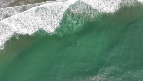 Vista-Aérea-De-Arriba-Hacia-Abajo-De-Surfistas-Y-Olas