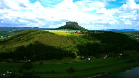 Drohnenaufnahmen-Mit-Stark-Abgestuftem-Blauem-Himmel-Und-Wolken-Mit-Atemberaubender-Landschaft,-Während-Sich-Die-Drohne-Einem-Ikonisch-Aussehenden-Berg-In-Der-Mitte-Europas-Nähert