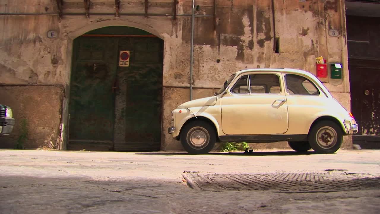 маленький автомобиль, припаркованный у старого каменного здания палермо италия