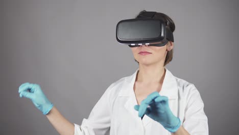 Feale-Arzt-Führt-Experimentelle-Medizinische-Eingriffe-Durch-Und-Trägt-Ein-Virtual-Reality-Headset,-Isoliert-Auf-Grauem-Hintergrund.-Modernes-Gesundheitskonzept.-In-4k-Gedreht