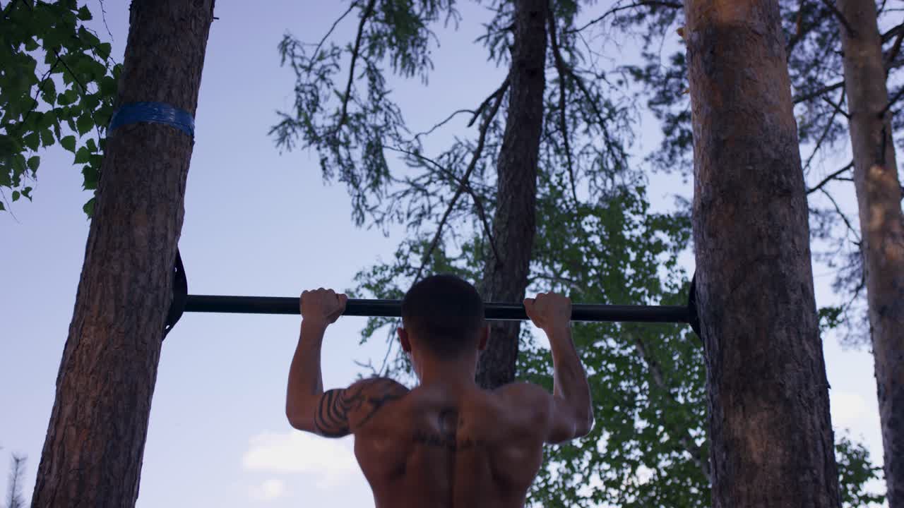 hombre haciendo pull-ups al aire libre