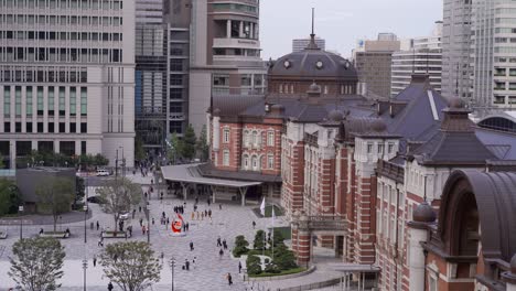 high above view out on the famous tokyo station red brick building with small people walking in front of it