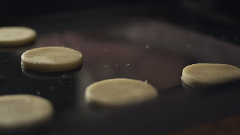 Placing-circles-of-linzer-cookie-dough-on-baking-sheet,-close-up