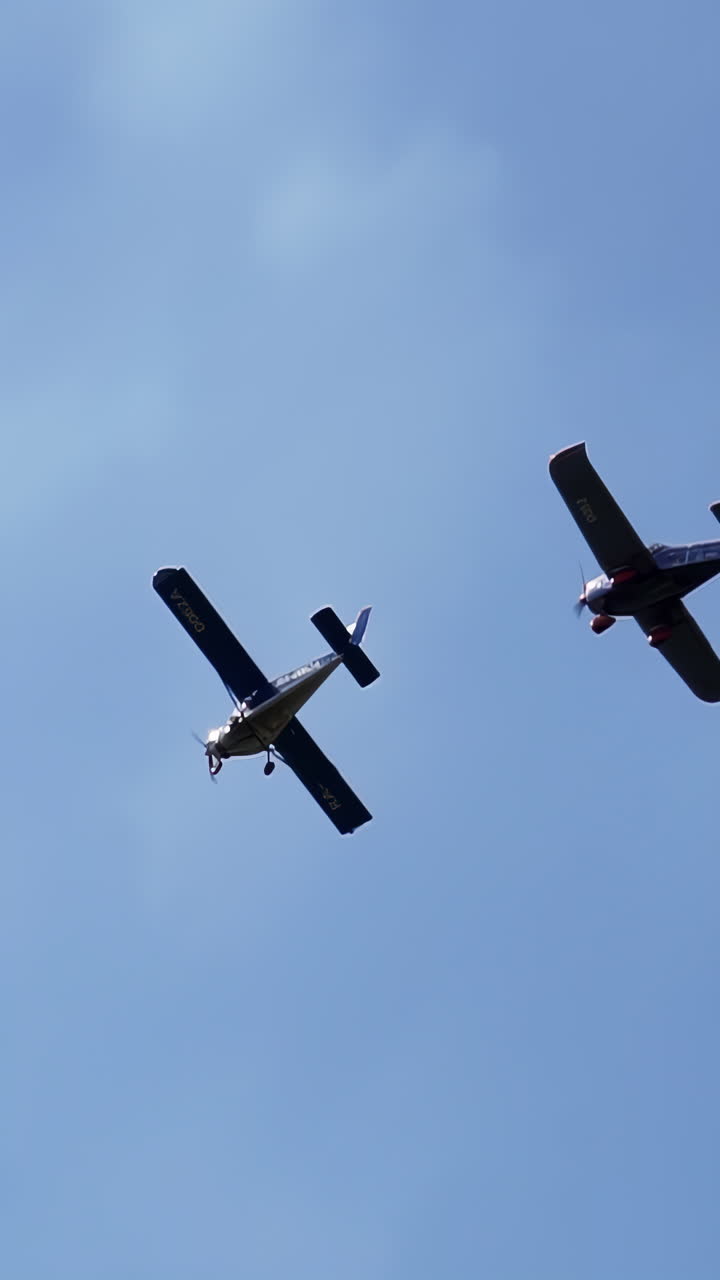 Two small planes flying in the sky