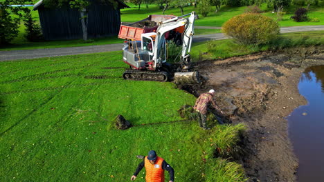men operating an excavator to dig pond
