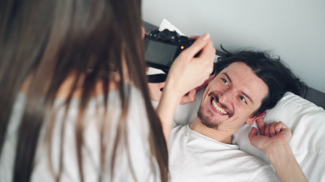 Couple taking a picture in bed