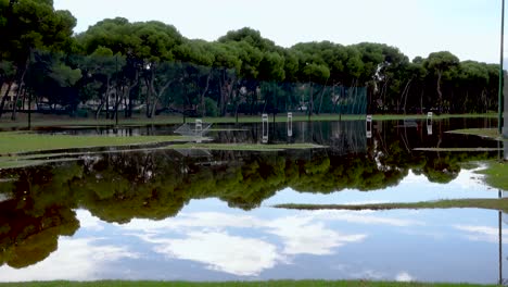 pelota de golf saltando por el agua al final de un campo de prácticas inundado por la gota fría