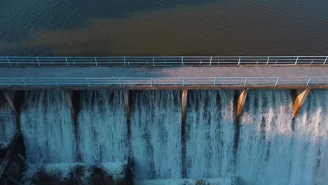 disparo aéreo de agua que fluye a través de la puerta de inundación de una presa de un lago hecho para el riego