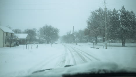 car driving in snow storm with snowflakes falling on windshield