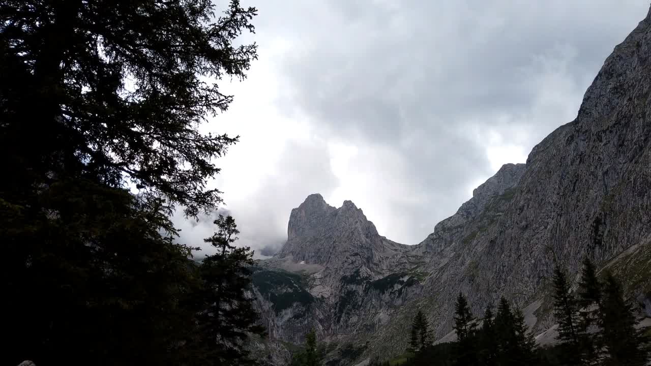 lapso de tiempo, moviéndose hacia arriba, mostrando la cumbre de los alpes alemanes con muchas nubes envolviéndose con haces de luz rompiendo un par de veces