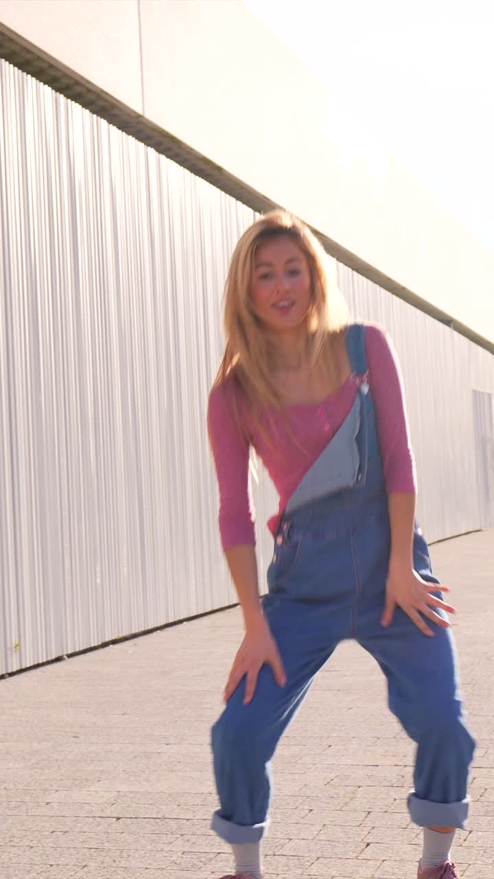 Woman Dancing in Overalls on Street