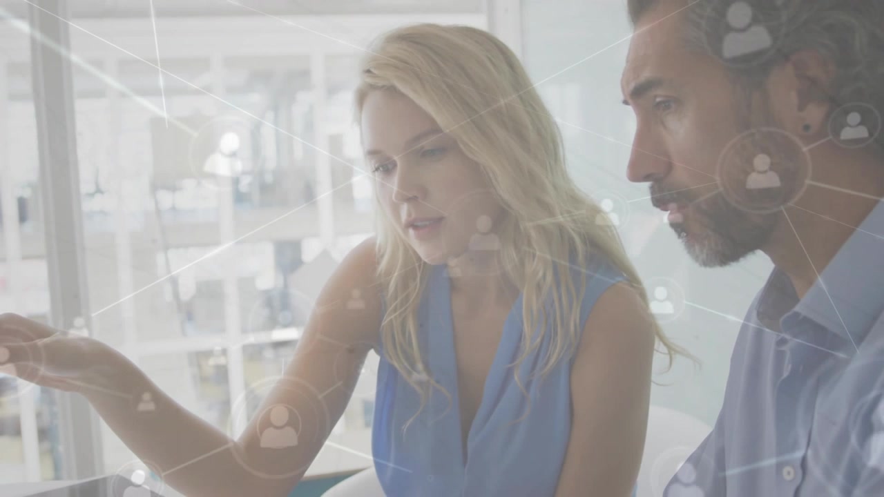 Woman pointing at screen initiating data overlay and peer collaborating on business deck via tablet