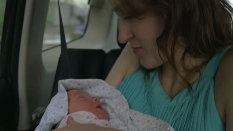 newborn baby sleeping on hands of his mother