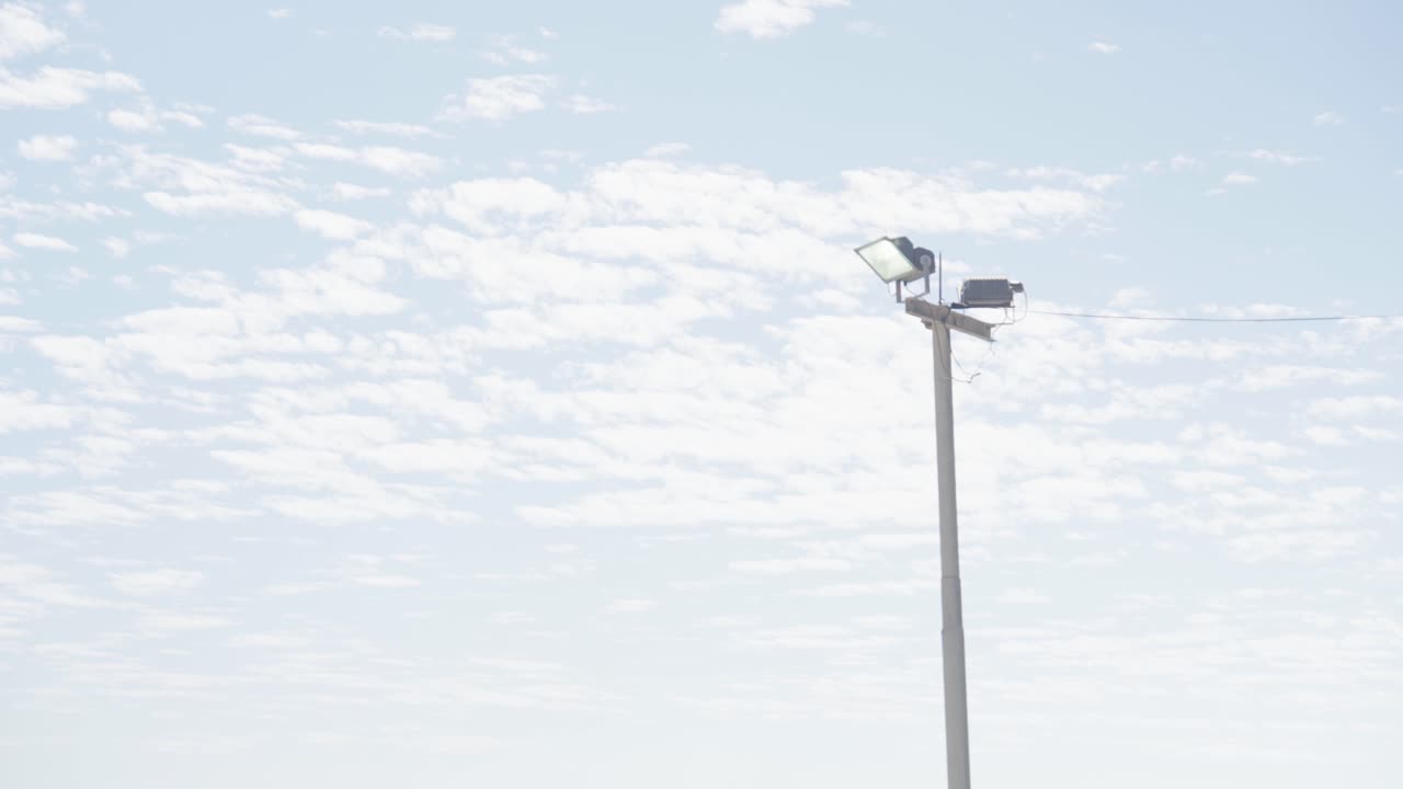 Palo della luce contro il cielo blu in un parcheggio.