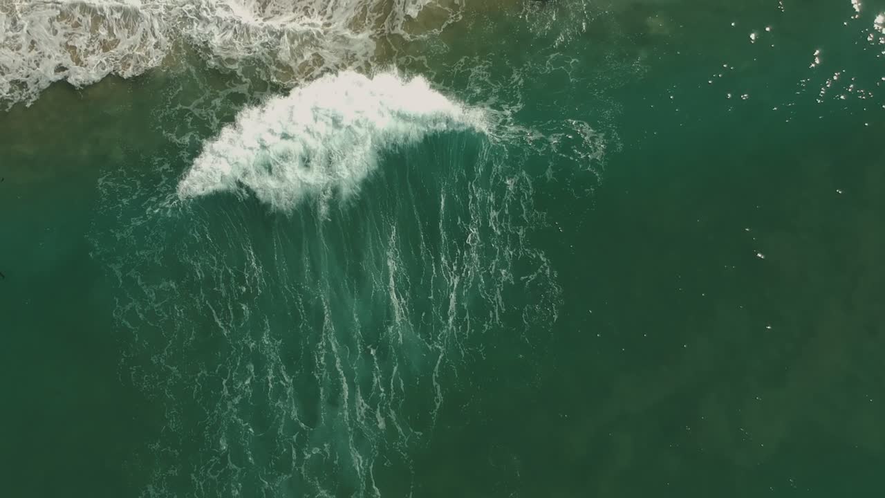Afternoon camera down drone view and following one small wave in Redondo Beach, California