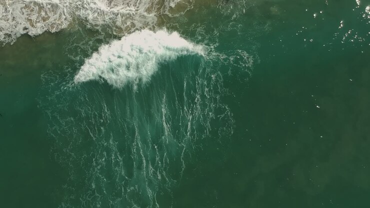 Afternoon camera down drone view and following one small wave in Redondo Beach, California
