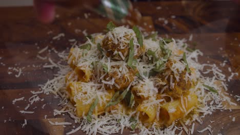chef agregando toques elegantes a la pasta con albóndigas y salsa de verduras