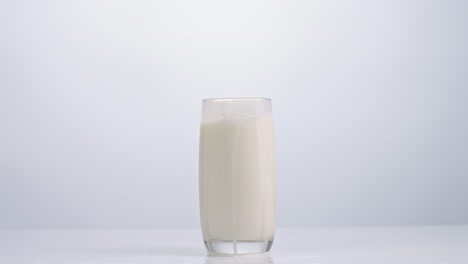 ice cubes falling in a glass of milk on white background