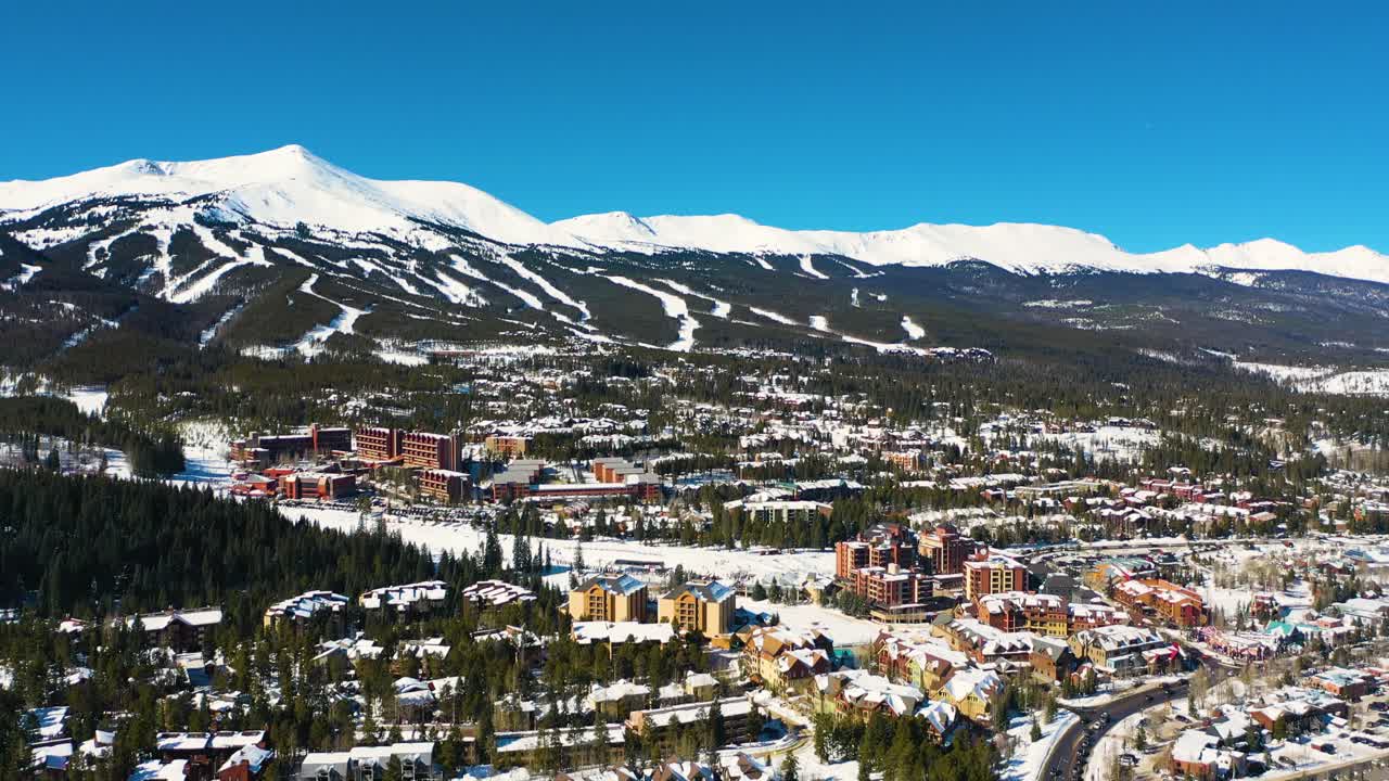 하얀 가루 눈으로 덮인 산 꼭대기에 있는 스키 슬로프 트레일의 공중 드론 전망