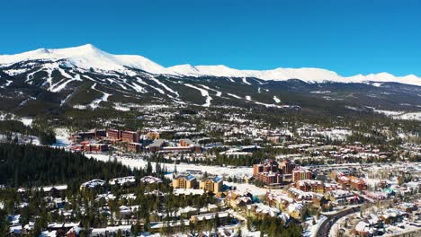 aerial drone view of ski slope trails on top of mountains covered in white powder snow