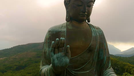 beautiful drone shot of the giant buddha in high mountains of hong kong, china - aerial tilt down