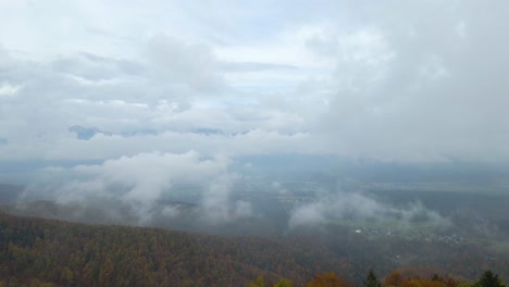 backward moving aerial showing historic ancient church built on the peak of mountain range.