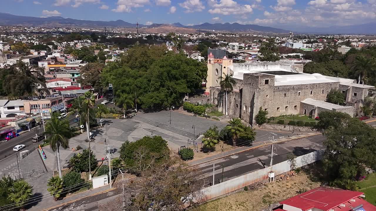 Aerial: Oaxtepec downtown during the day with cityscape and city sign in Morelos, Mexico, establishing drone shot
