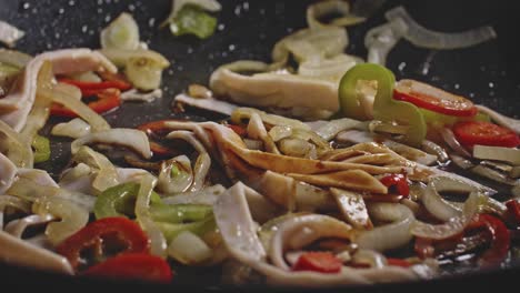 pouring sauce in a wok with onions and peppers, macro shot