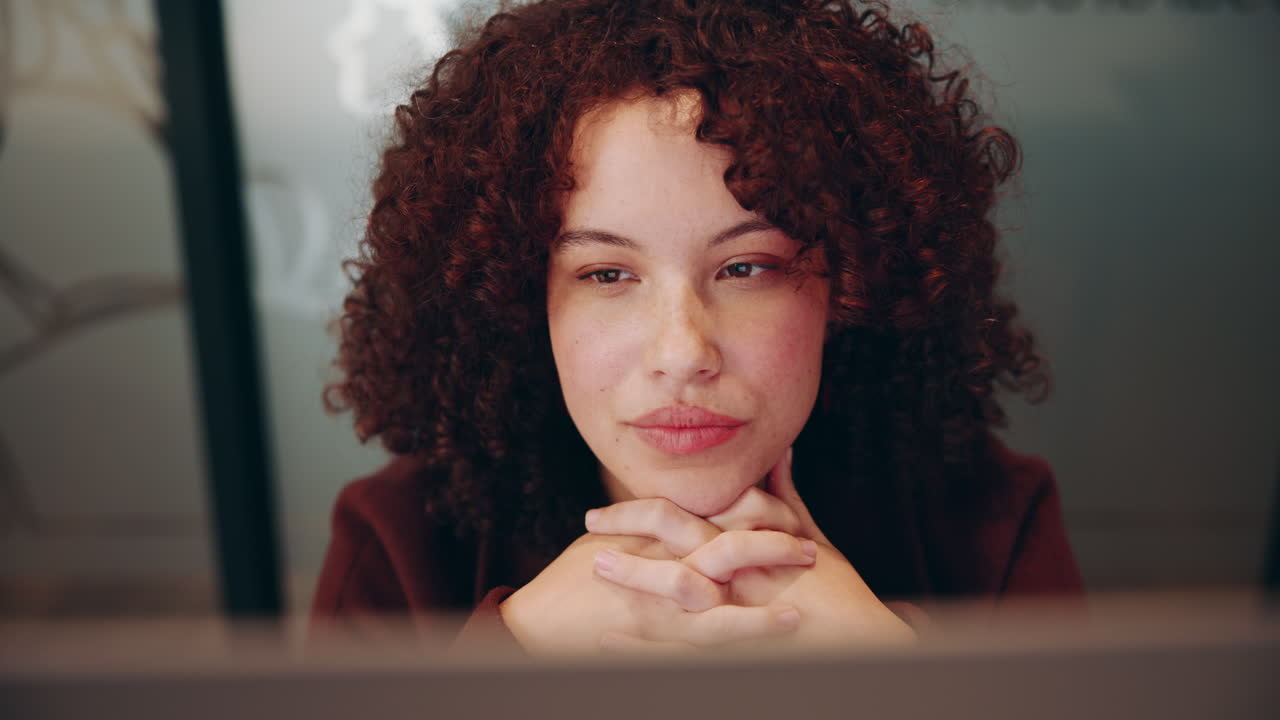 una mujer joven trabajando en su computadora.