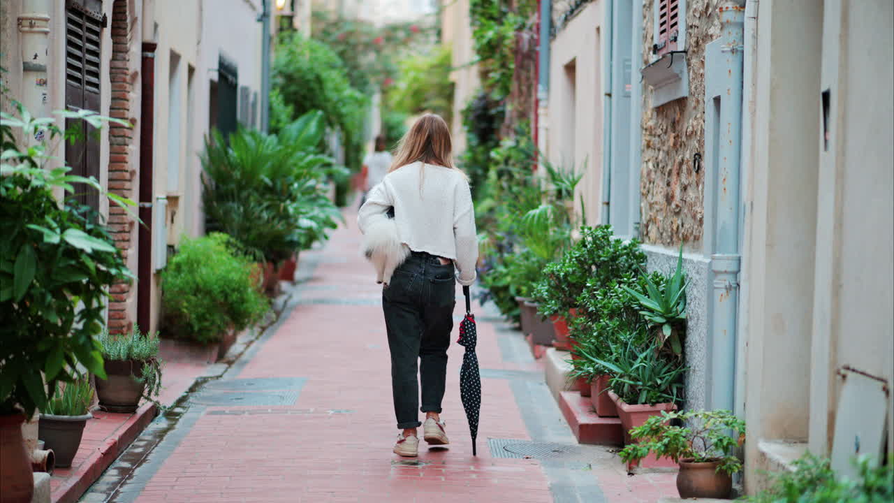 Woman walking on a street with many plants in Cannes, France
