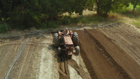 Vintage-tractor-working-in-the-outdoor-plantation,-preparing-the-land-for-cultivation,-amending-concept